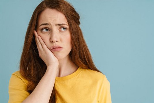 Patient in South End holding cheek in pain