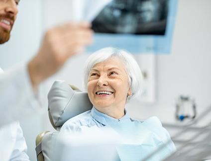 Dentist reviewing a dental X-ray with dental implant patient