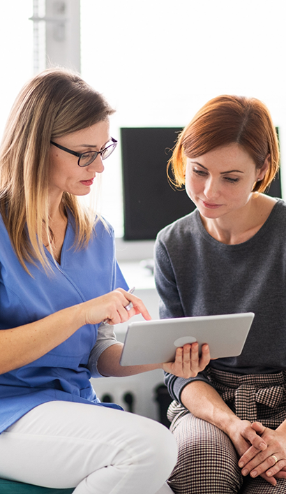 Peabody dental team member showing a tablet to a patient