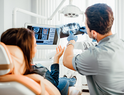 Dentist showing a patient an x ray of their teeth