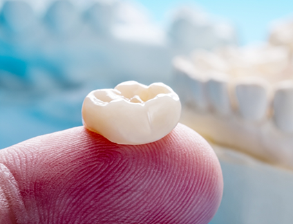 Close up of a dental crown on a finger