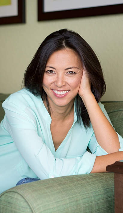 Woman sitting on an armchair and smiling with dental implants in Peabody