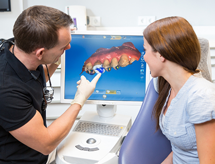 Dentist showing a patient a screen with a digital impression of her teeth