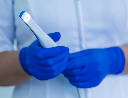 Dental professional holding a white pen like intraoral camera