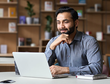 Man smiling while looking at laptop