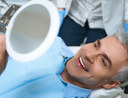 a patient checking his smile with a mirror