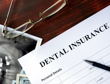 a dental insurance form next to a dental X-ray