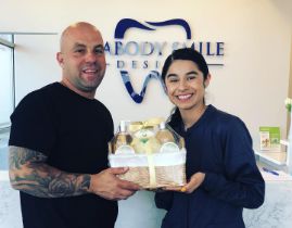 Peabody dentist and team member holding a gift basket