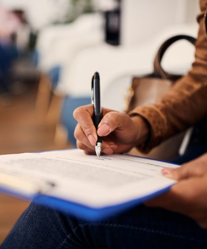 Dental patient filling out paperwork on a clipboard in waiting room