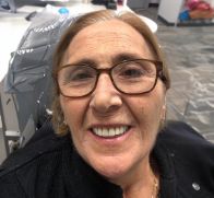 Older woman with glasses smiling in dental chair