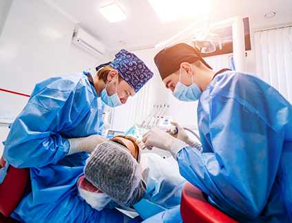 Two dental professionals performing a procedure on a patient