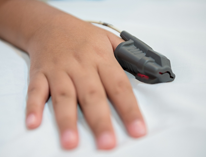 Hand with a pulse oximeter on the thumb